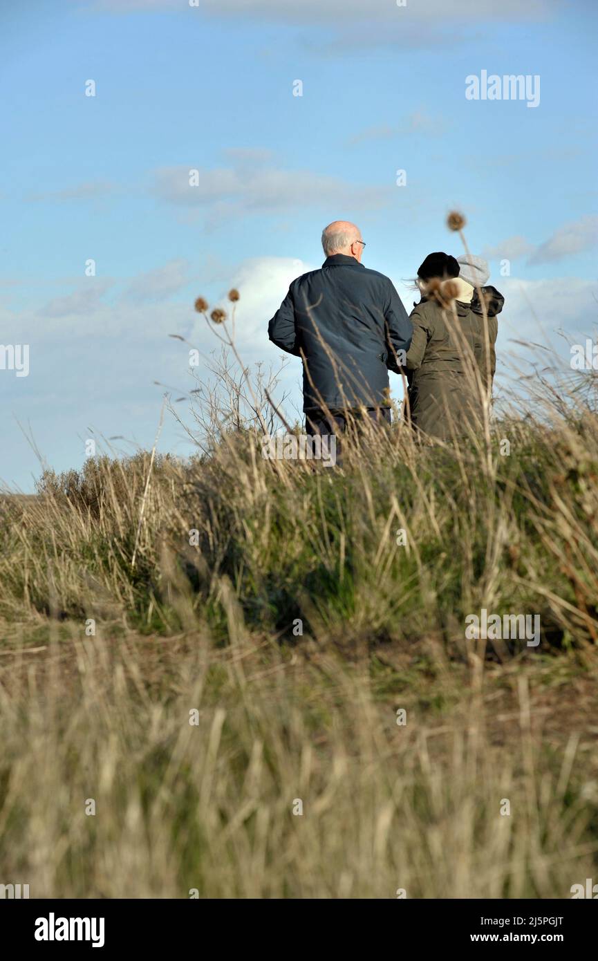 older couple standing together on grassy field Stock Photo