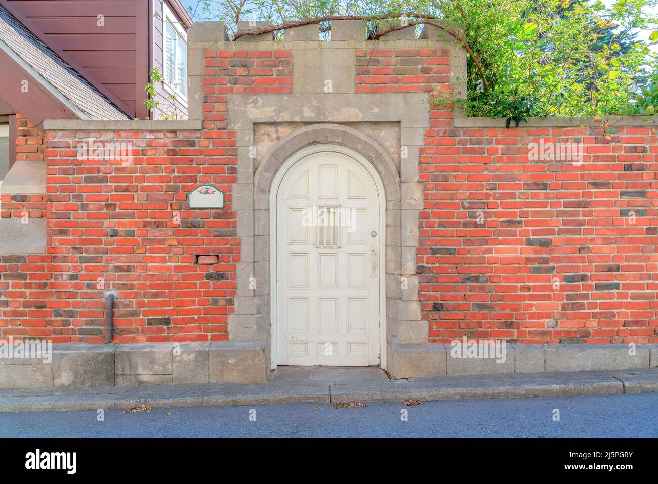 Arched white wooden gate door with brick walls at San Francisco