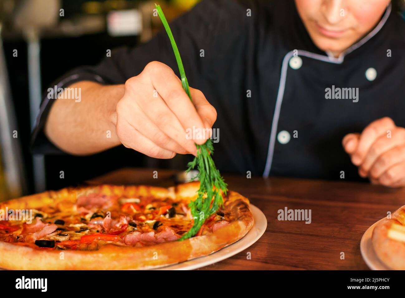 pizza preparation oiling by dill oil ready pizza. male hand Stock Photo