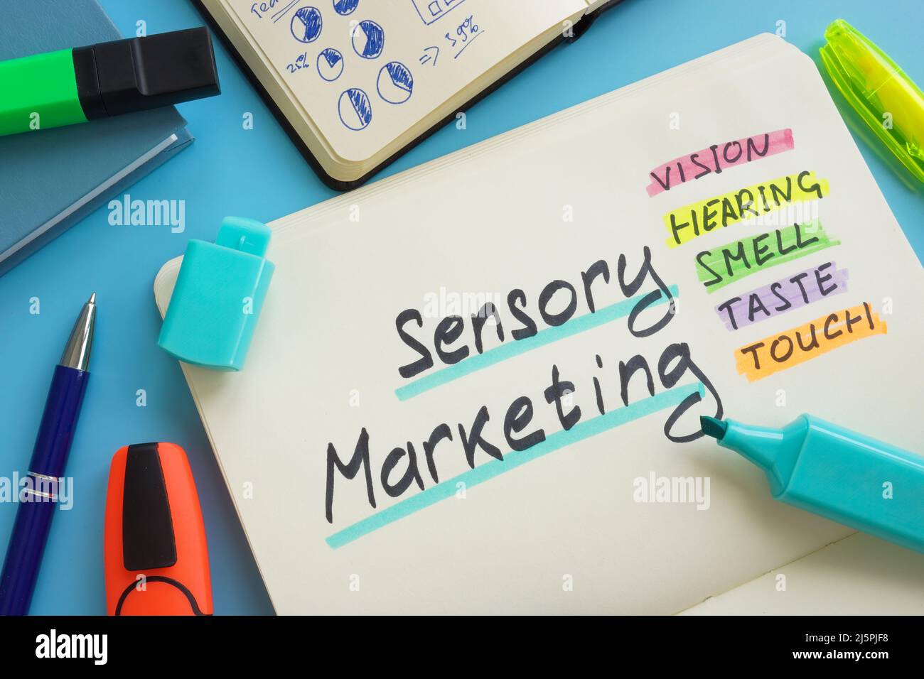 Open notepad and marks about Sensory marketing. Stock Photo