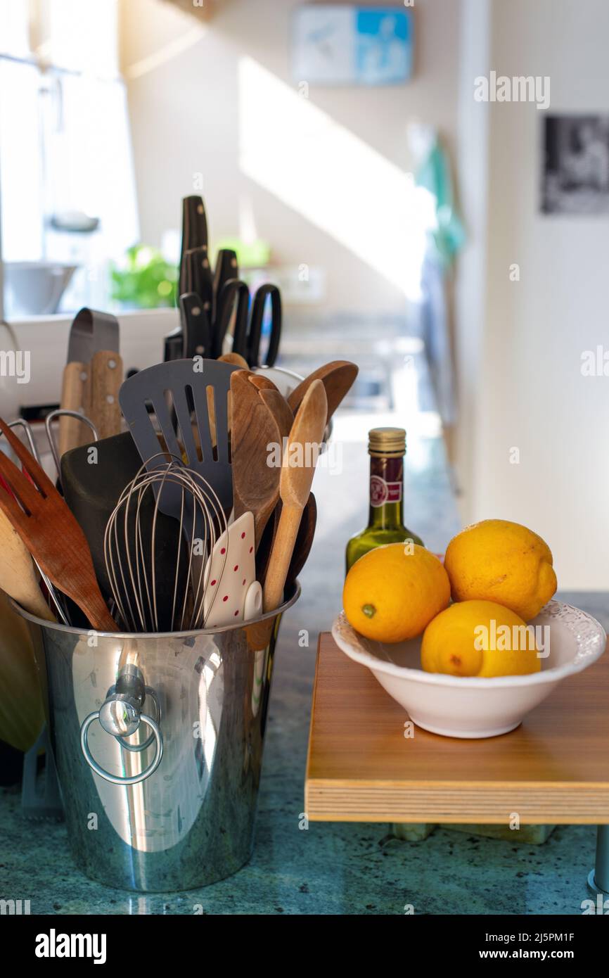 bucket with kitchen utensils and a bowl with lemons Stock Photo Alamy