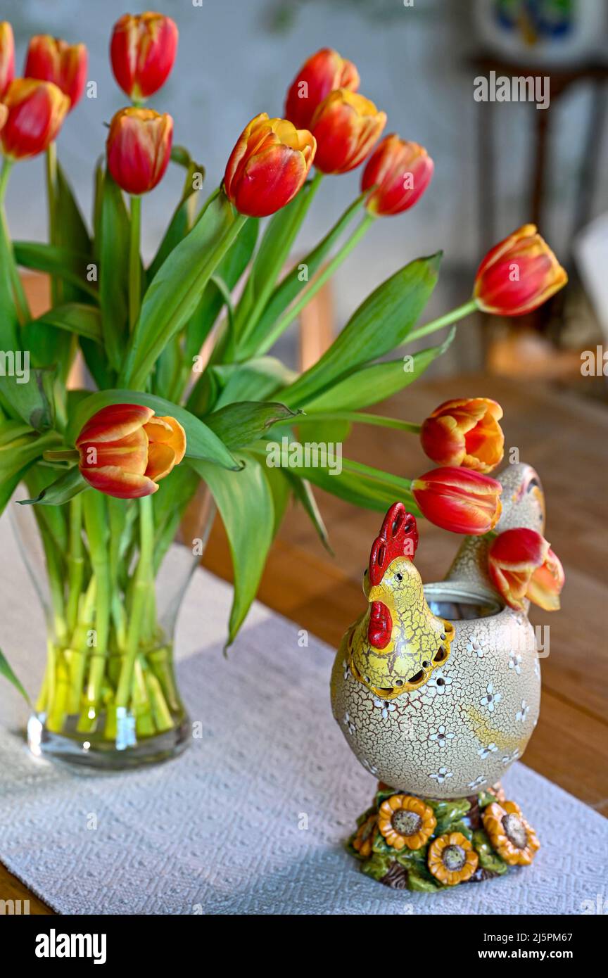 Vase with tulips and rooster standing on table on Easter Stock Photo