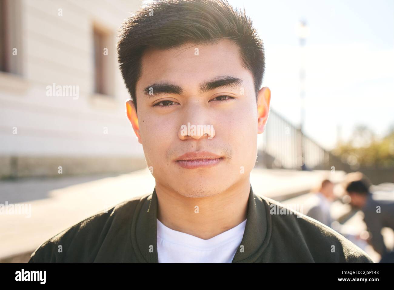 Outdoor portrait of an Asian man looking at the camera with a serious face and intense look. Close up of a serene human face - Concept of real people Stock Photo