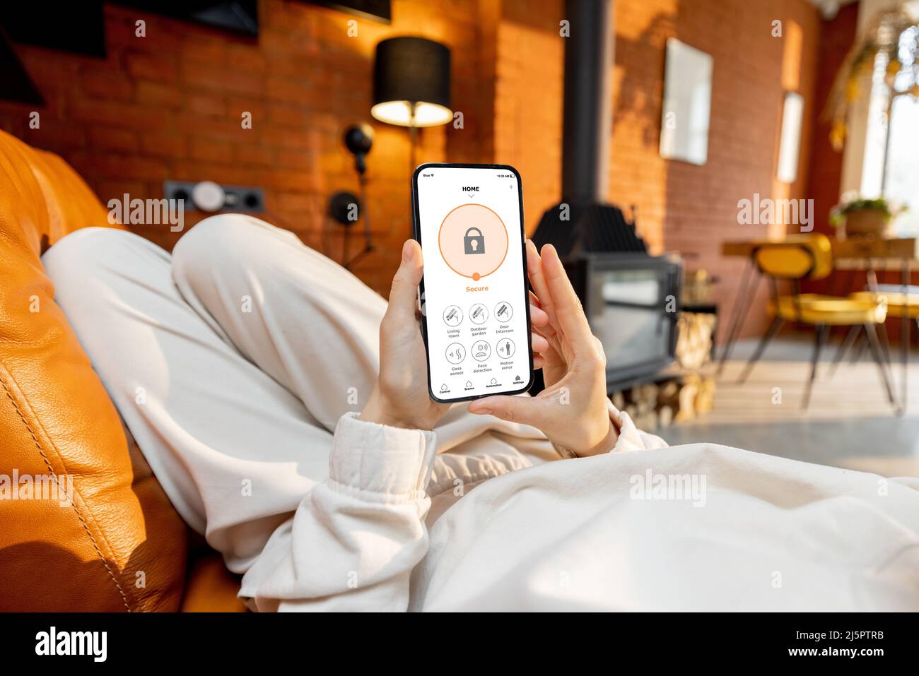 Woman using phone with running smart home security application Stock Photo