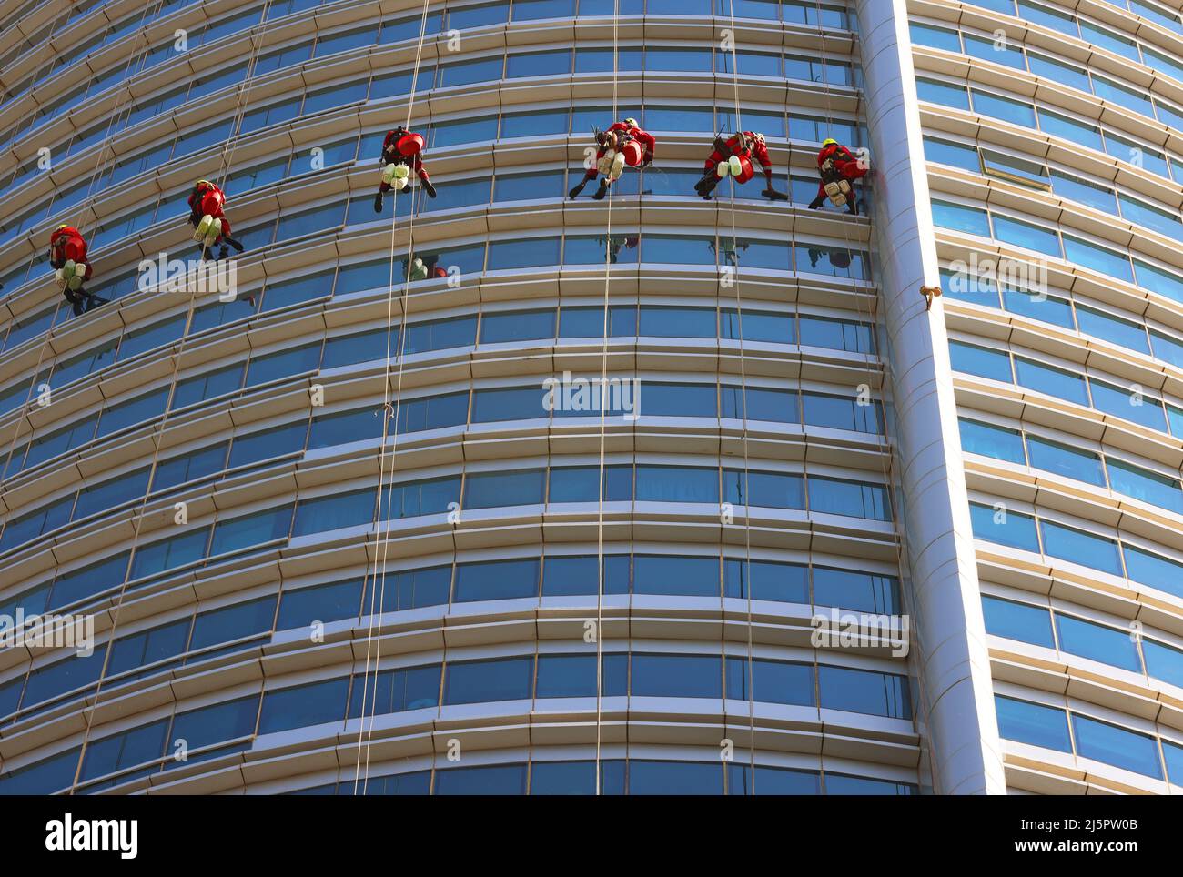 Dubai,  moderne Architektur, Fensterputzer reinigen oder waschen die Fenster an einem Wolkenkratzer mit atemberaubender Aussicht  auf die Skyline Stock Photo