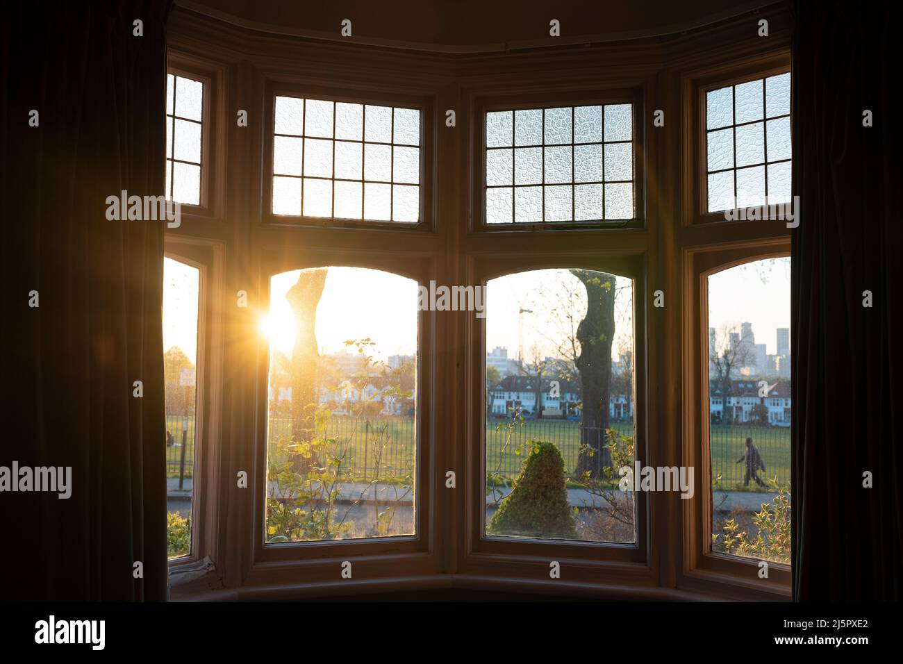 The view at sunset through a bay window in the front room of a south London suburban home, on 21st April 2022, in London, England. Stock Photo
