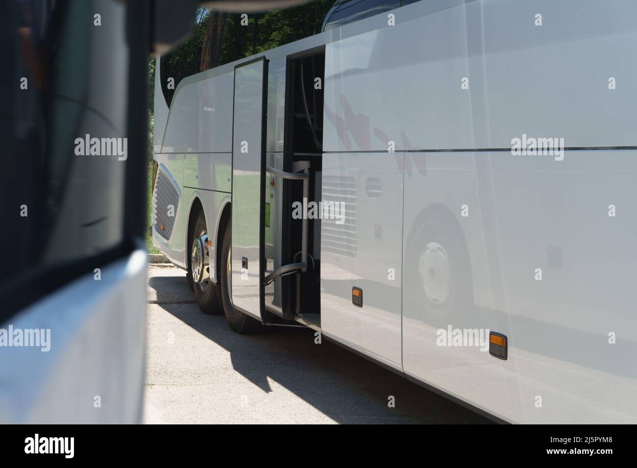 Modern buses for transporting people stand at the bus stop. Closeup of