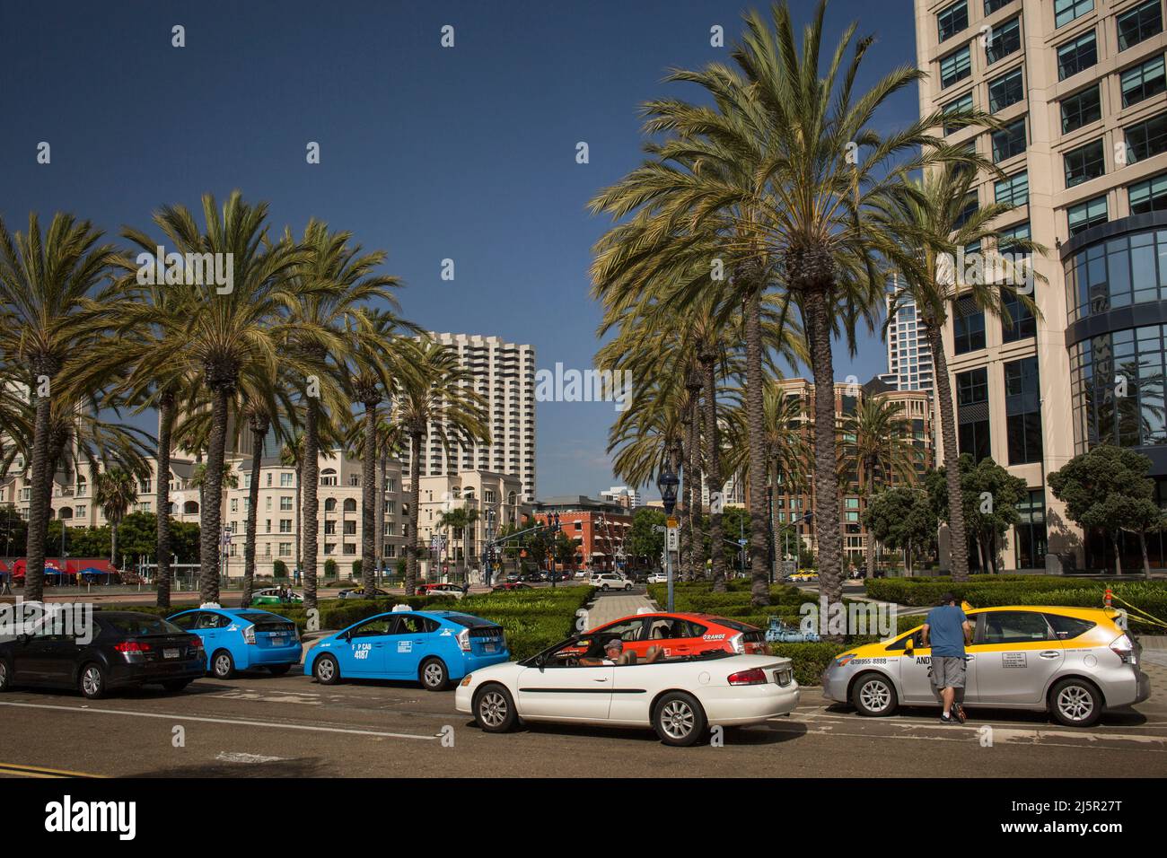 Convertible car passing by a taxi stop in front of the Manchester Grand Hyatt Hotel in San Diego Stock Photo