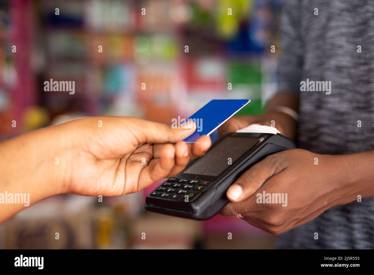 Close up shot of customer paying money by tapping credit card to swiping machine at grocery shop - concept of digital payment, contact less Stock Photo