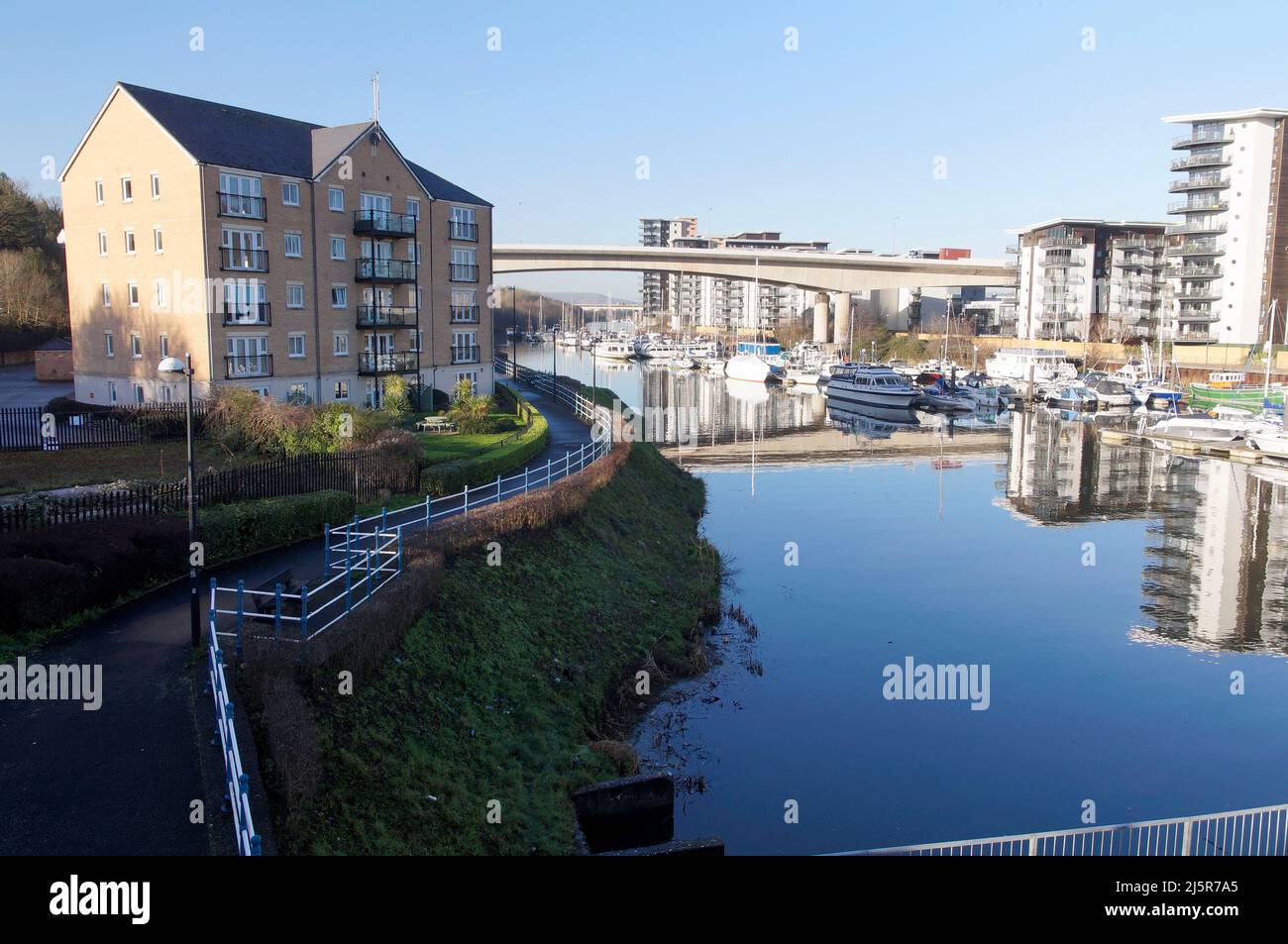 Clear blue sky on a sunny day, Ely river as it enters Cardiff Bay and ...