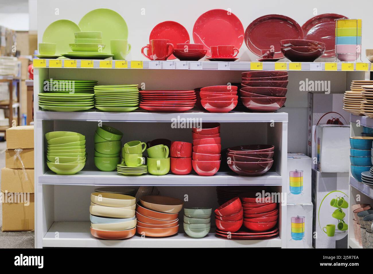 Rows of different multicolored cups, bowls and plates for home on