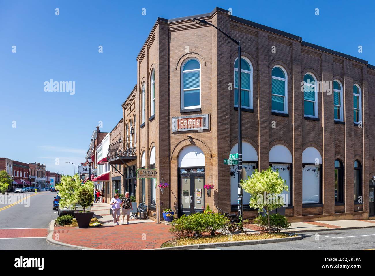 MOORESVILLE, NC, USA-17 APRIL 2022: Street view showing corner of Main Street and Moore Avenue, focus on 'On Tap Crafty Brews', with people on sidewal Stock Photo