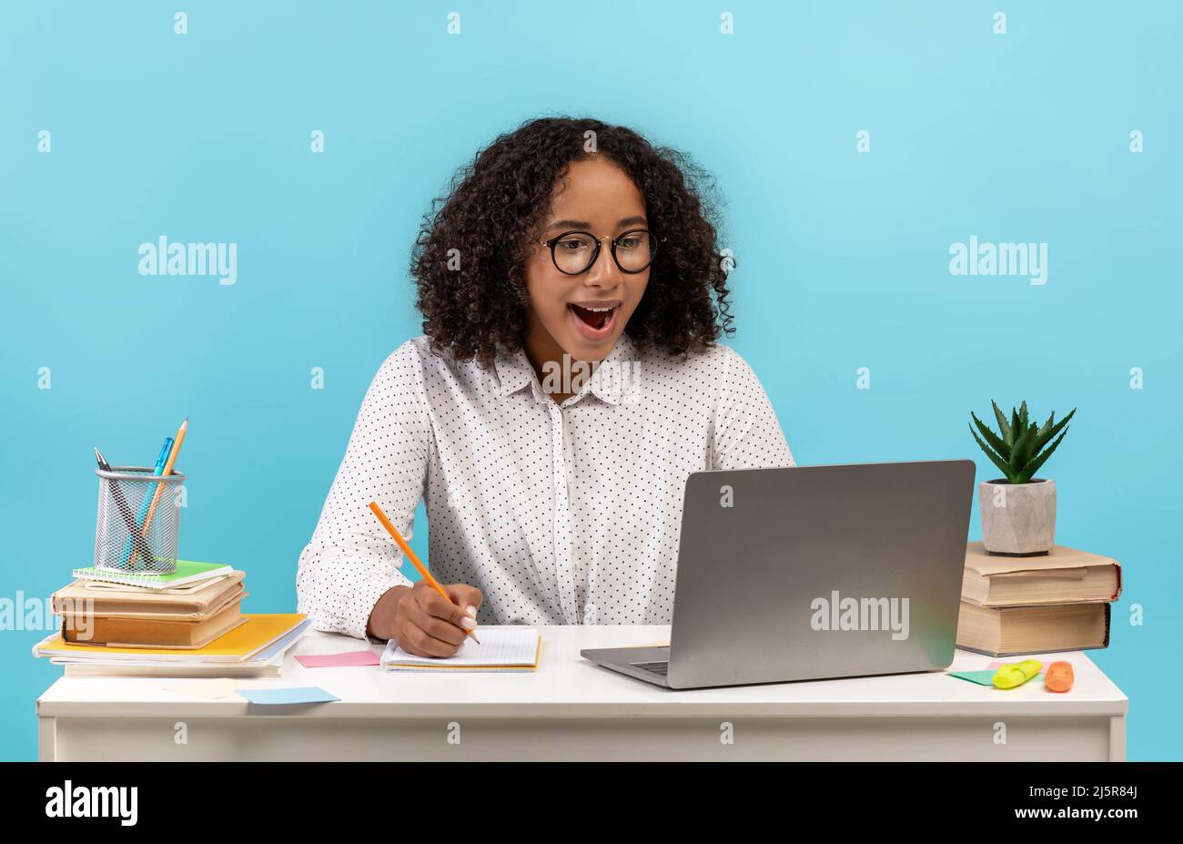 Online education concept. Excited young black female student sitting at ...