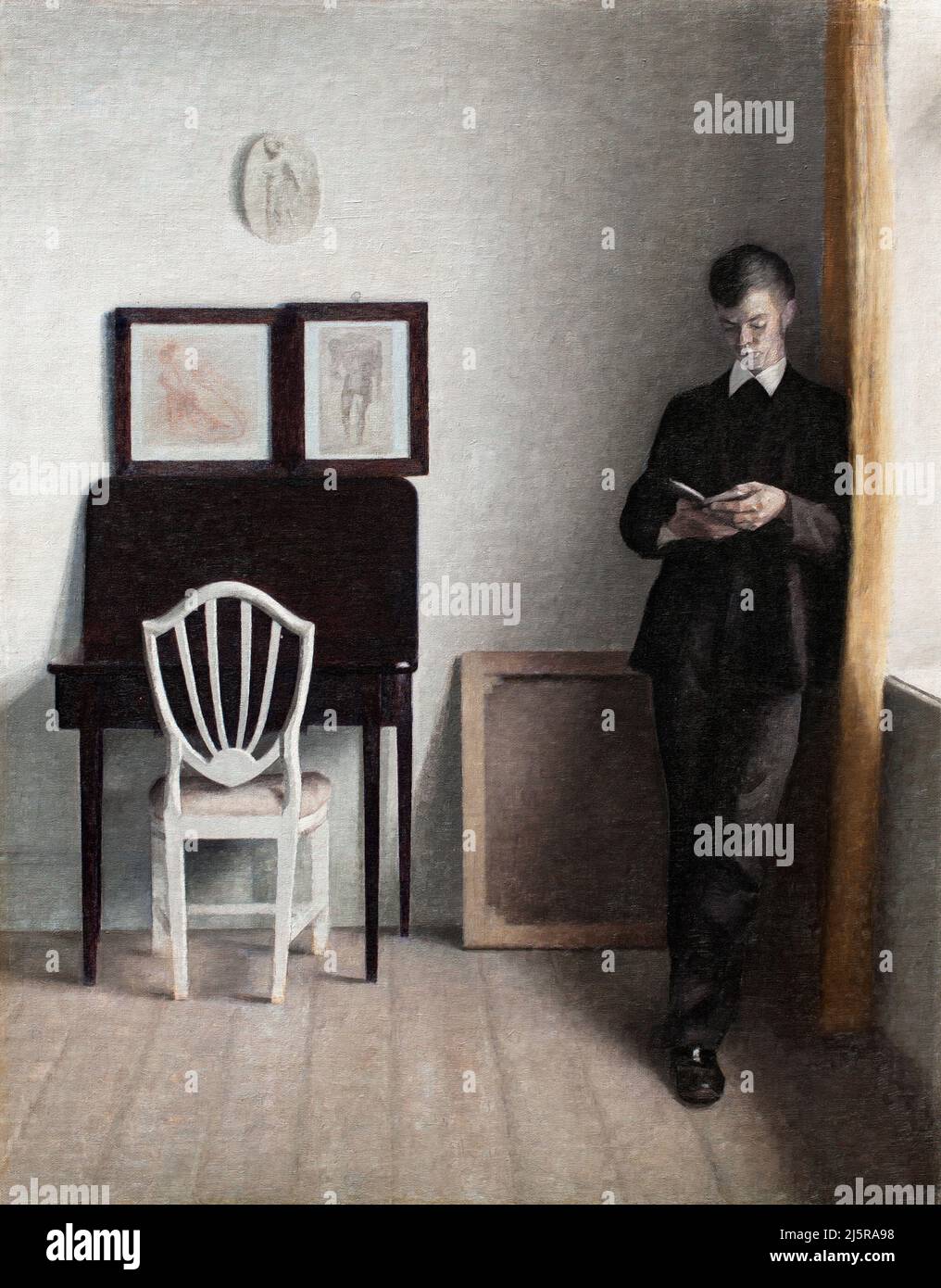 Interior with Young Man Reading by the Danish artist, Vilhelm Hammershoi (1864-1916), oil on canvas, 1898 Stock Photo