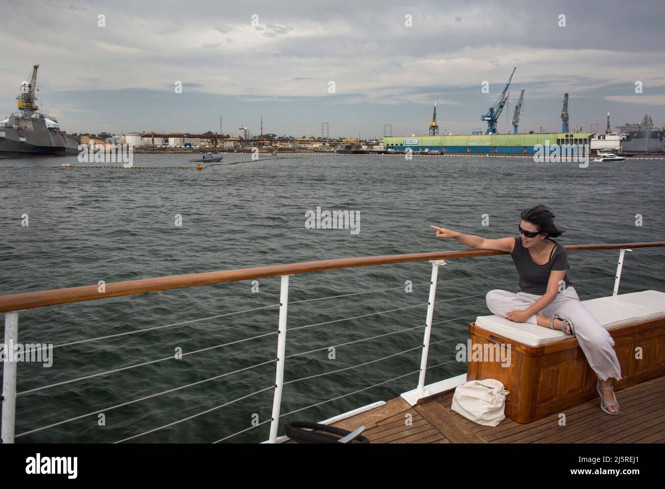 Woman pointing at the South Bay ships from a sightseeing cruise Stock Photo