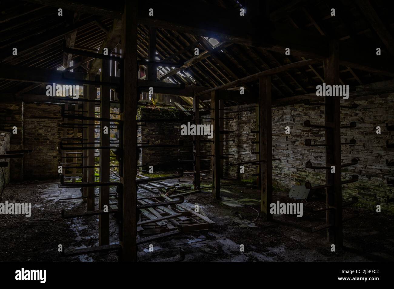 Old store room in abandoned slate quarry with metal racks, disused