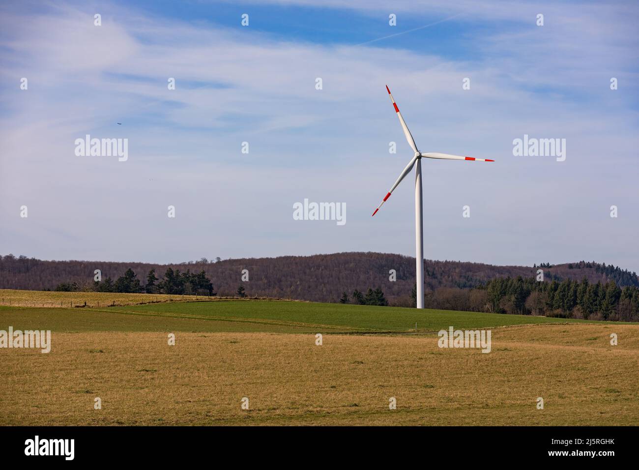 Aerial view of a wind turbine with red and white rotor blades in a rural landscape Stock Photo