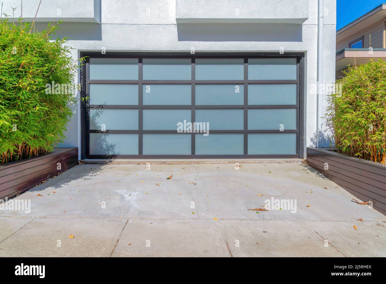 Modern garage door with frosted glass panel and black grids at San