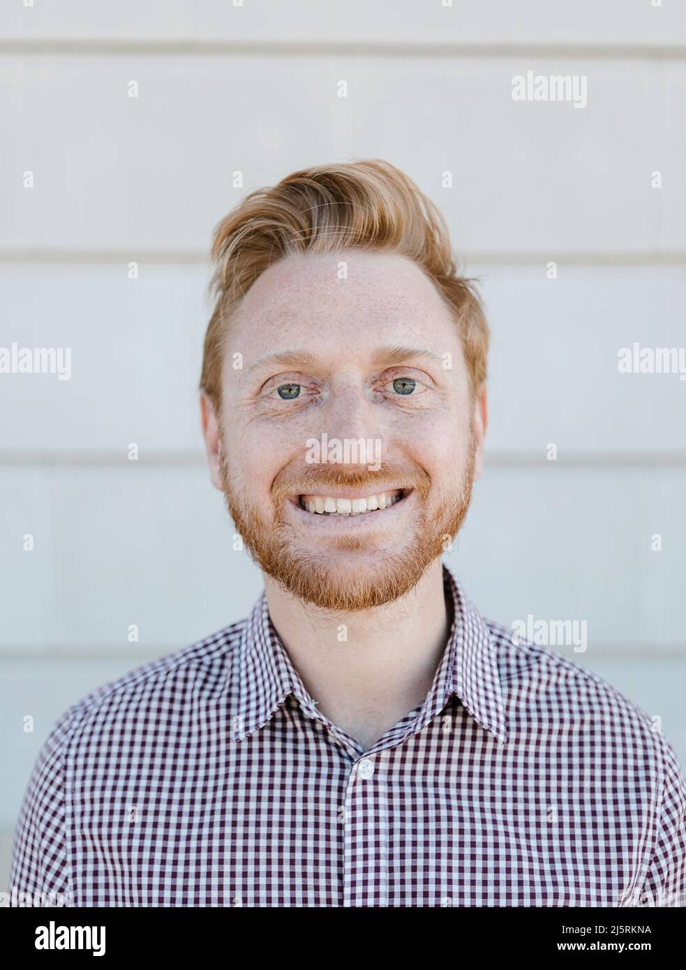 Portrait of smiling hipster red haired young man outdoors Stock Photo