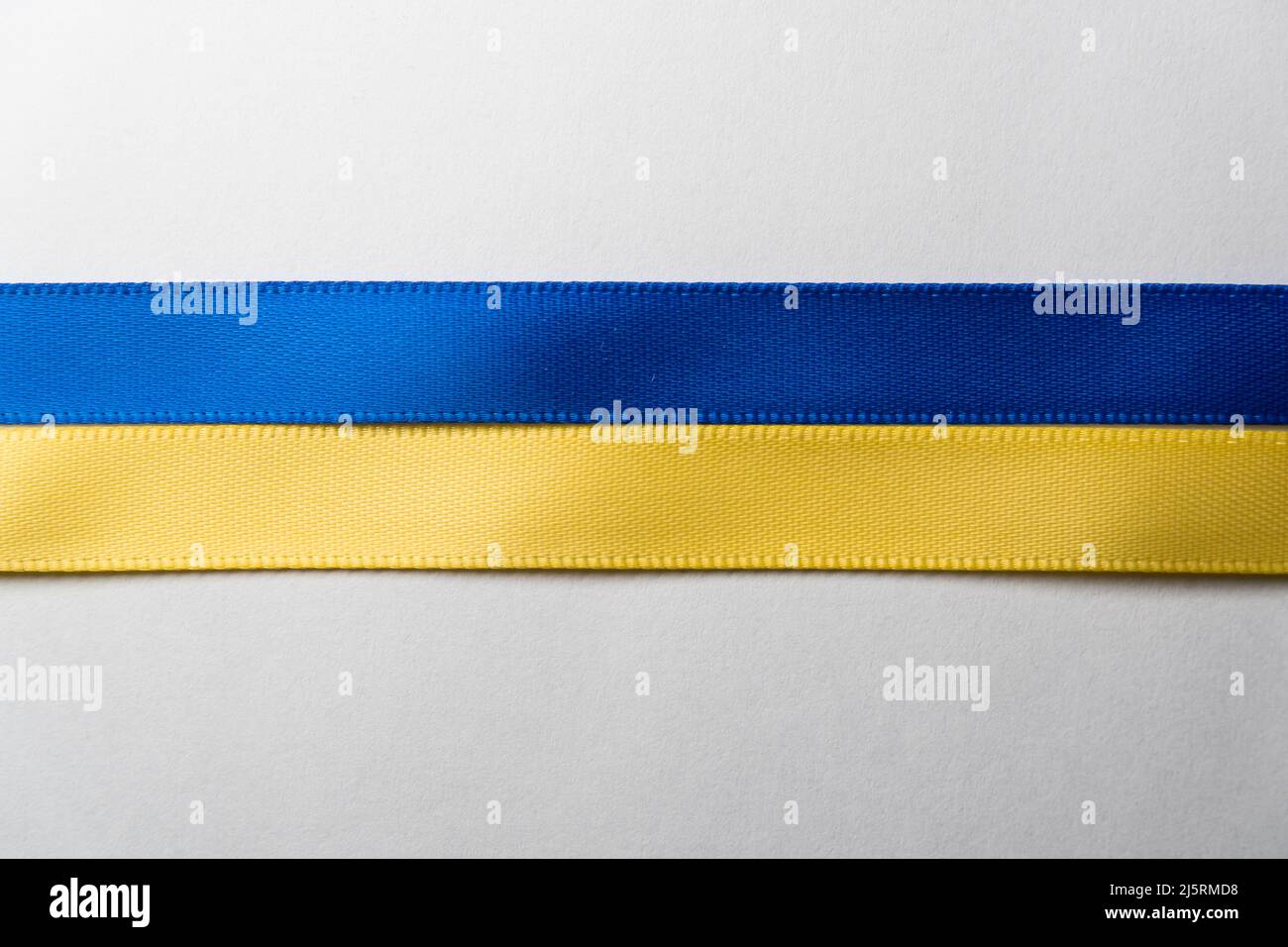 Blue and yellow ribbon on white paper Stock Photo