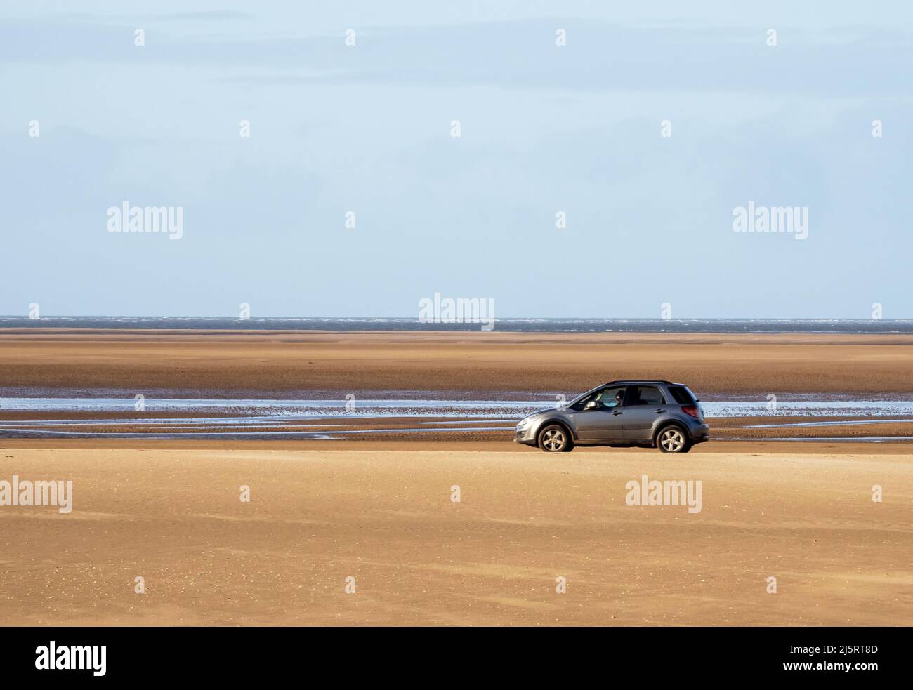 A car on the beach at Roanhead, Barrow in Furness, Cumbria, UK with the