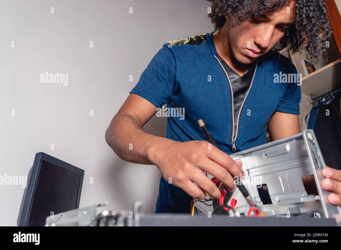 young brunette male technician working on desktop computer maintenance ...