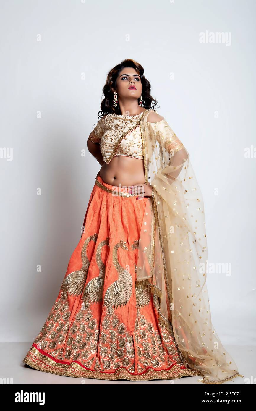 Beautiful Indian woman in a golden and orange lehenga choli Stock Photo