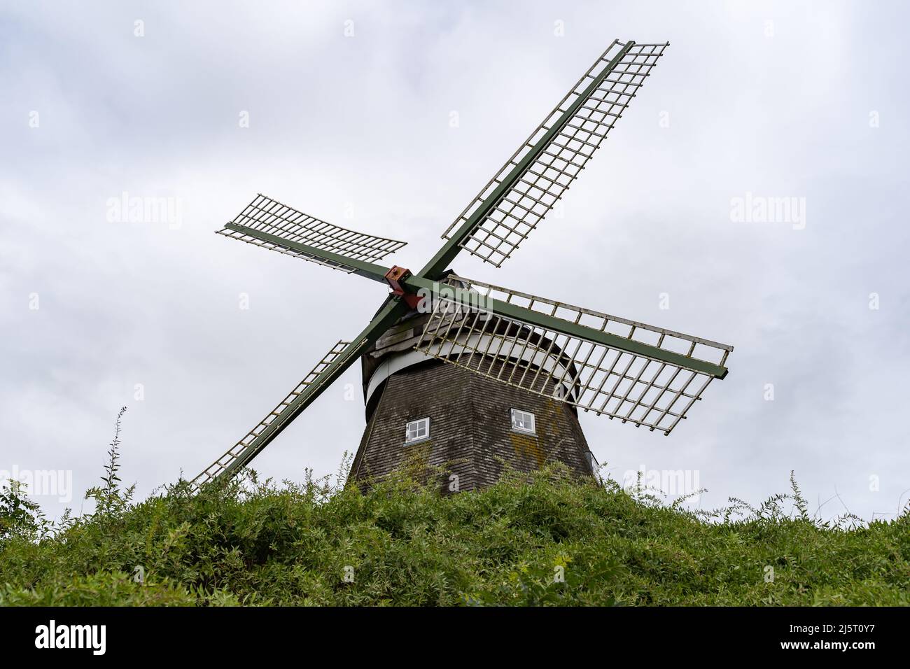 The famous windmill in front of the sky. An old historic building made of wooden planks. Sightseeing in Röbel to visit the landmark. Stock Photo