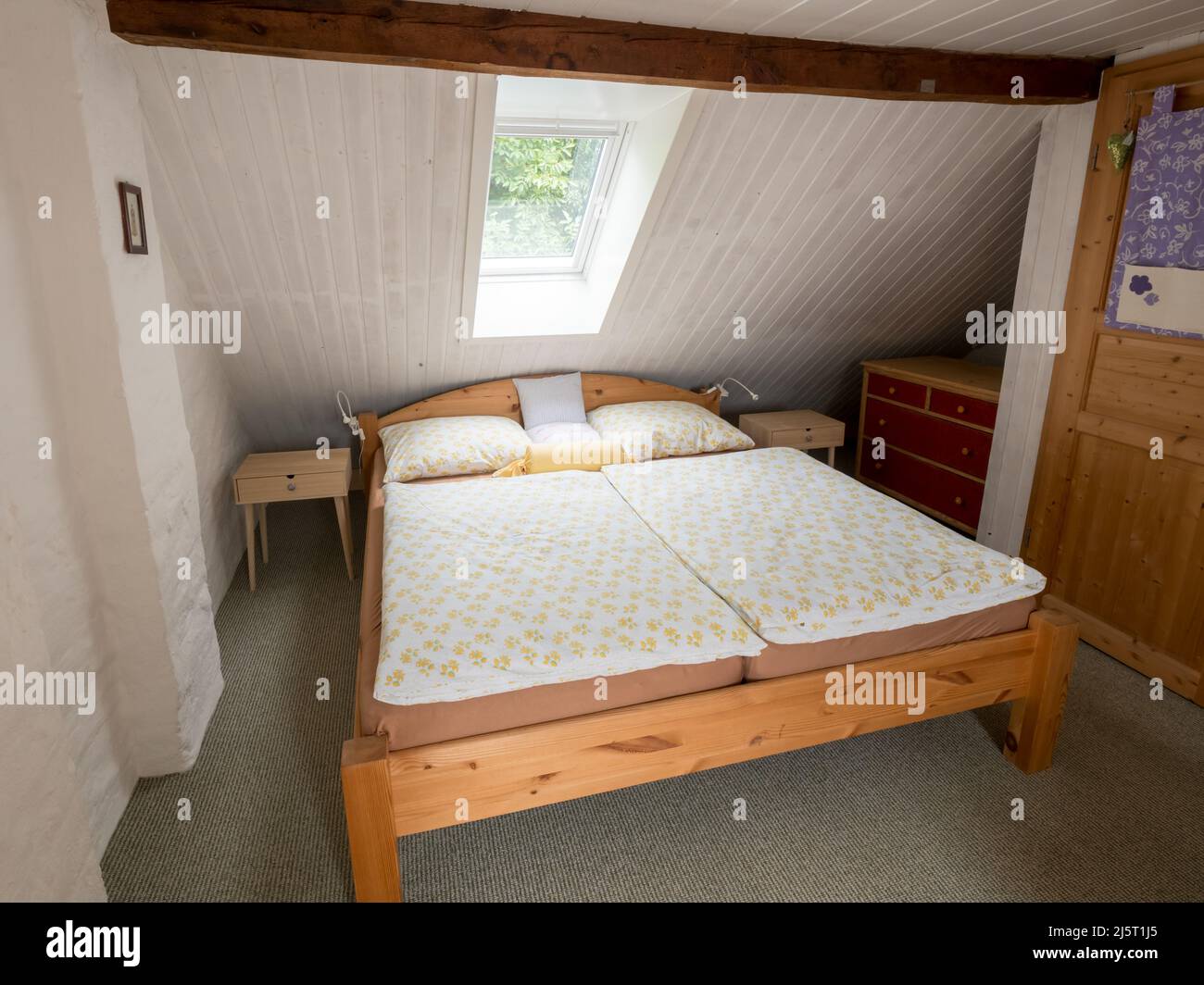 Big bed in a cozy retro bedroom. Vintage furniture in a hotel room. Stock Photo