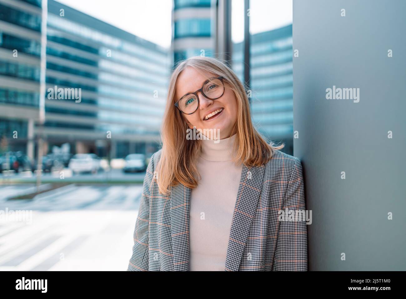 Confident businesswoman smiling at the camera in urban background. Business people concept Stock Photo
