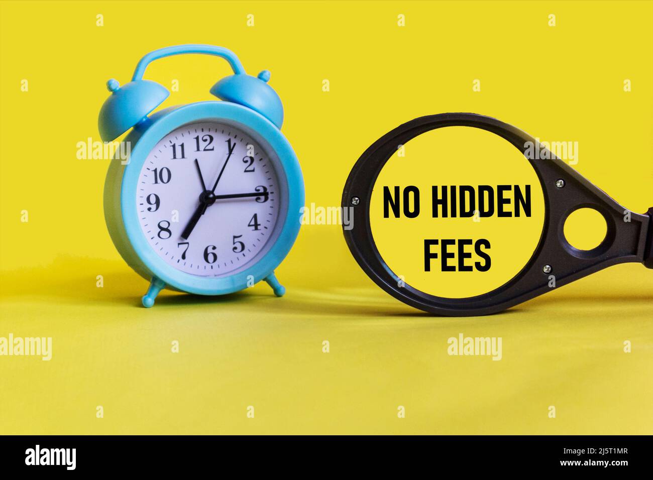 No hidden fees text under magnufying glass. Fees and taxes business concept. Stock Photo