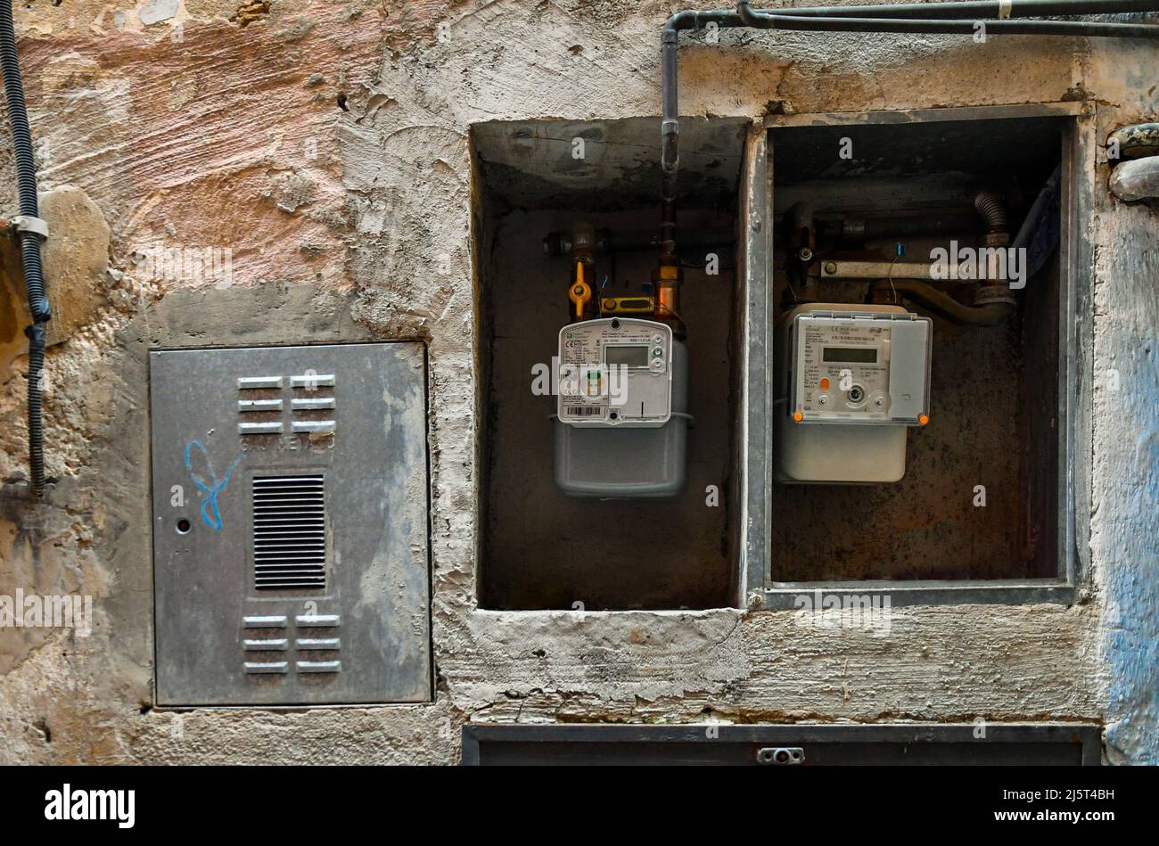 Detail of electricity and gas meters on the exterior wall of an old house, Italy Stock Photo