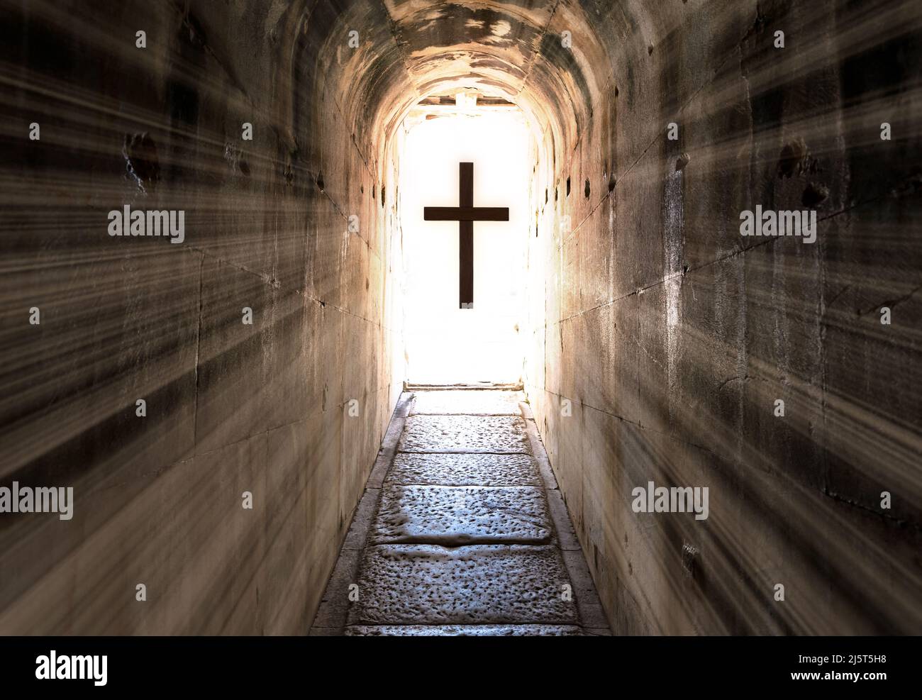 Dark tunnel exit and jesus christ cross with backlight. Concept of heaven after christianity and life after death. Stock Photo