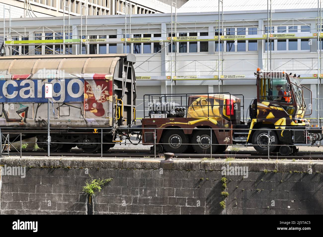 Basel, Switzerland - April 2022: Specialist road rail vehicle being used to shunt a heavy cargo train in the city's port on the Rhine River Stock Photo