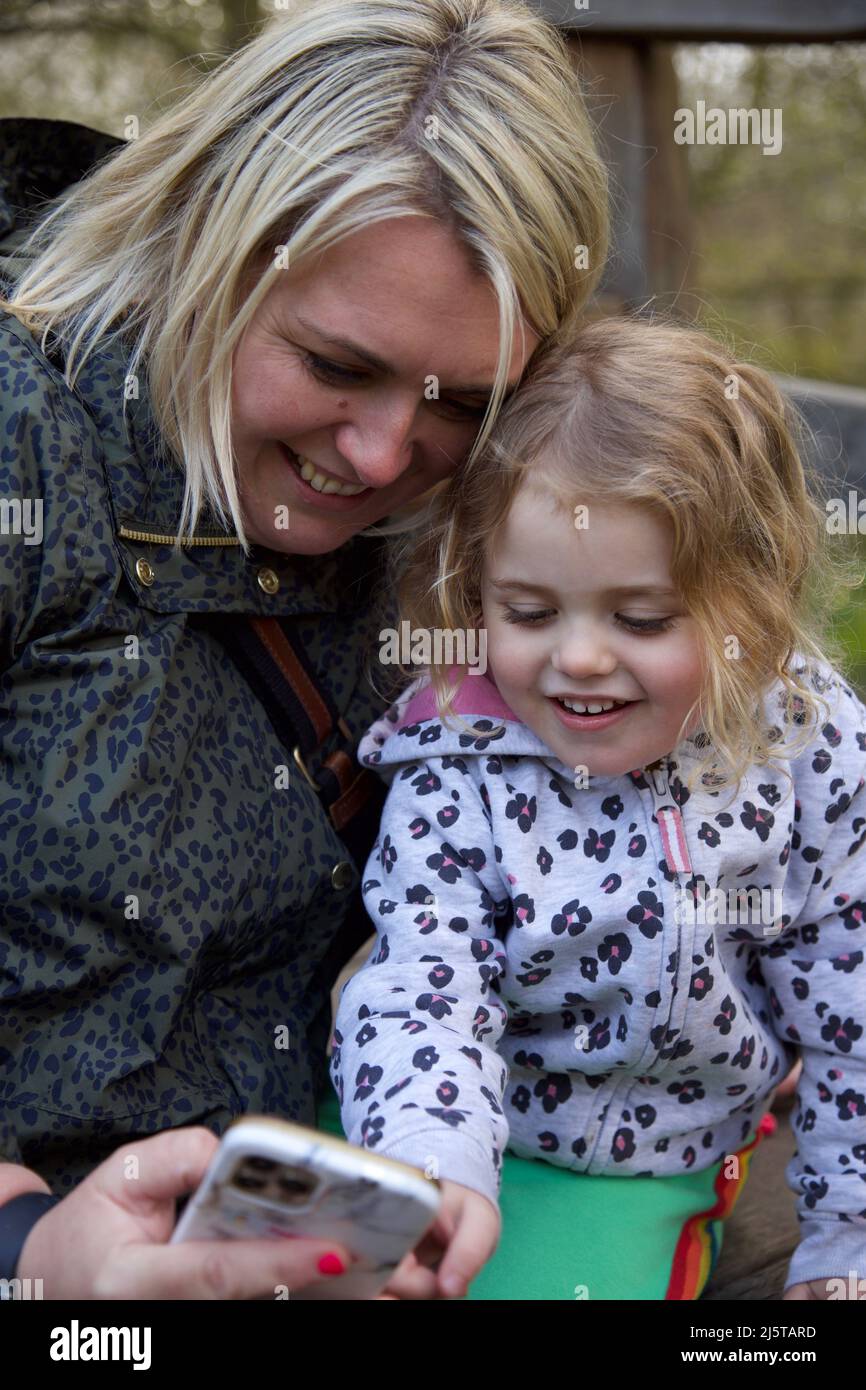 Mum and daughter looking at a mobile phone Stock Photo Alamy