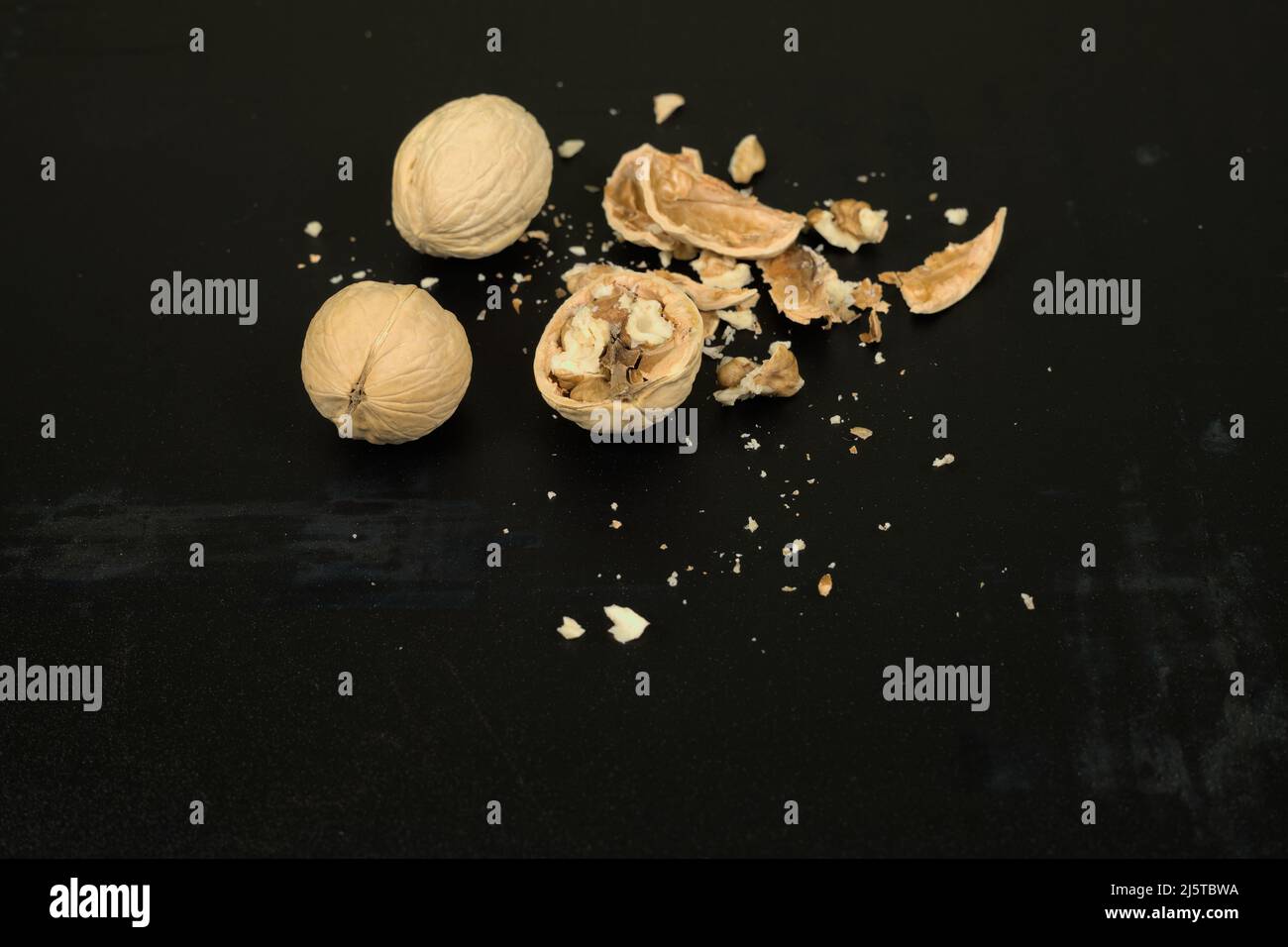 Three walnuts on a dark scratched background Stock Photo