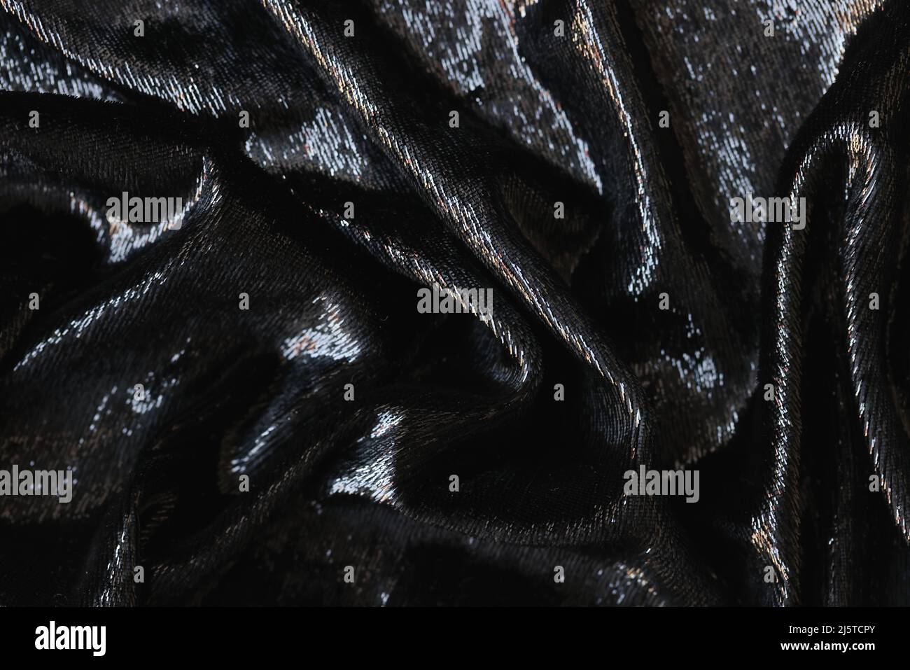 Closeup of tousled shiny black silk fabric closeup Stock Photo