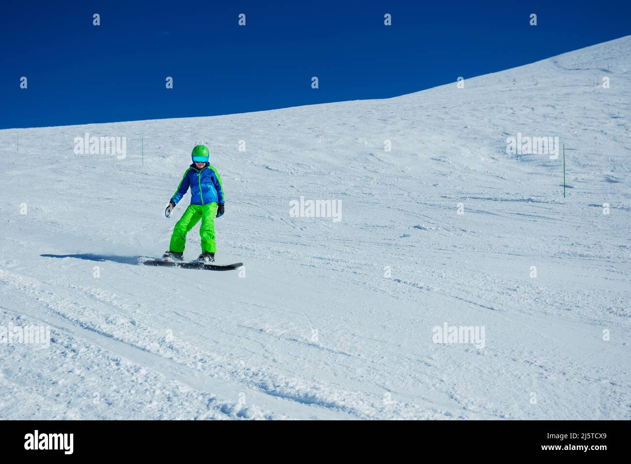 Action snowboarder boy go downhill image on snowboard, side view Stock Photo