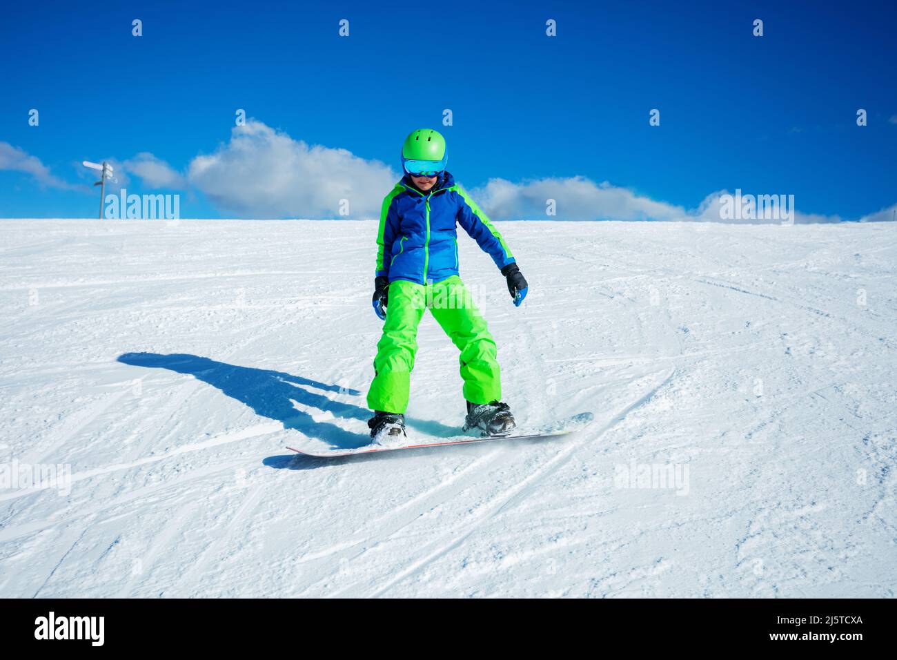 Front view of the boy snowboard down mountain slope track Stock Photo