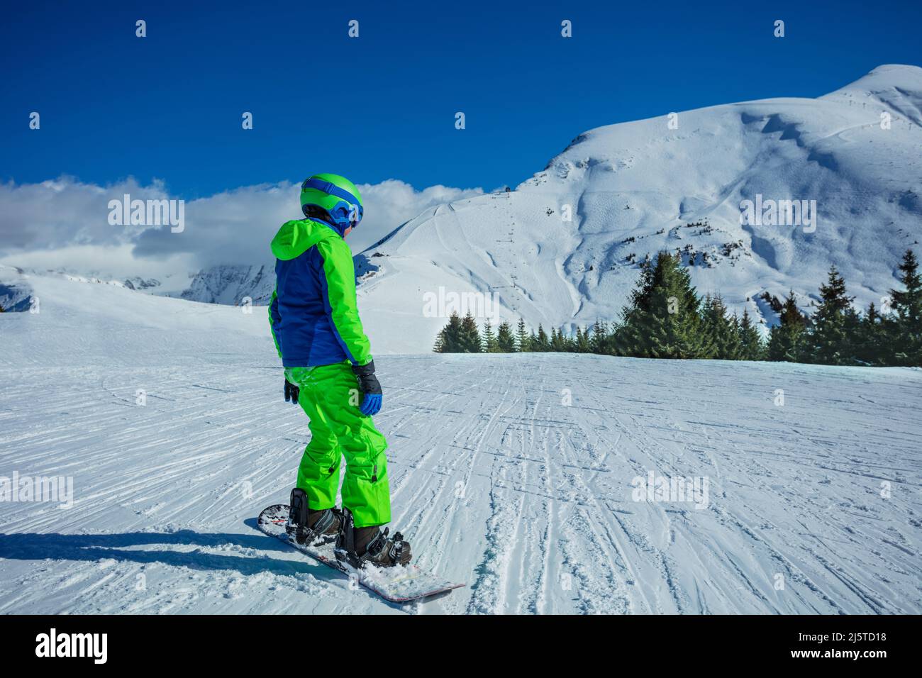 Boy ride snowboard with winter sport outfit on mountain top Stock Photo