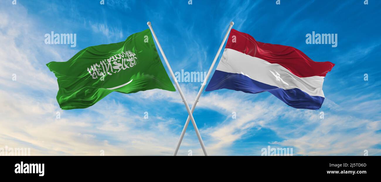 two crossed flags Saudi Arabia and Netherland waving in wind at cloudy ...
