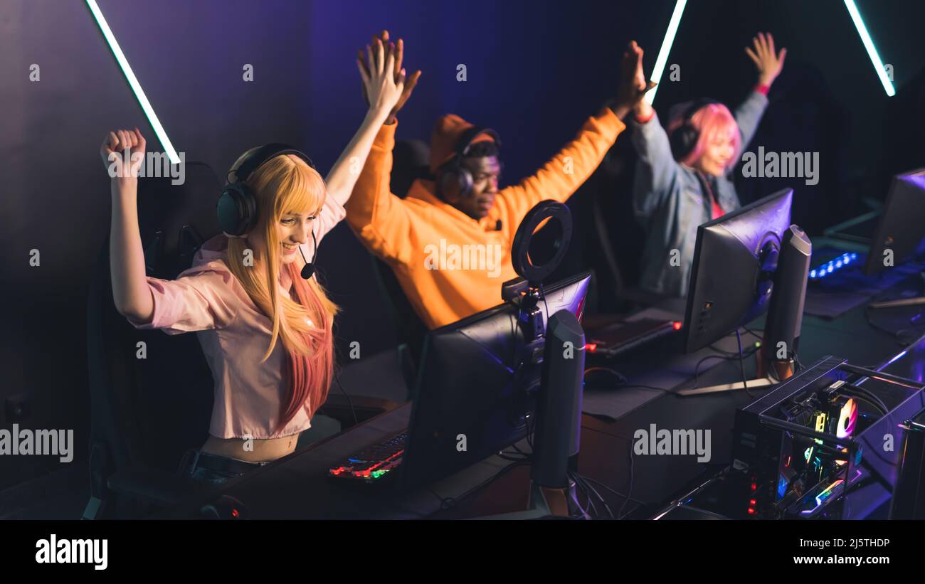 Team of multiracial gamers winning the tournament. Internet cafe interior. Female and male players. Success. High quality photo Stock Photo