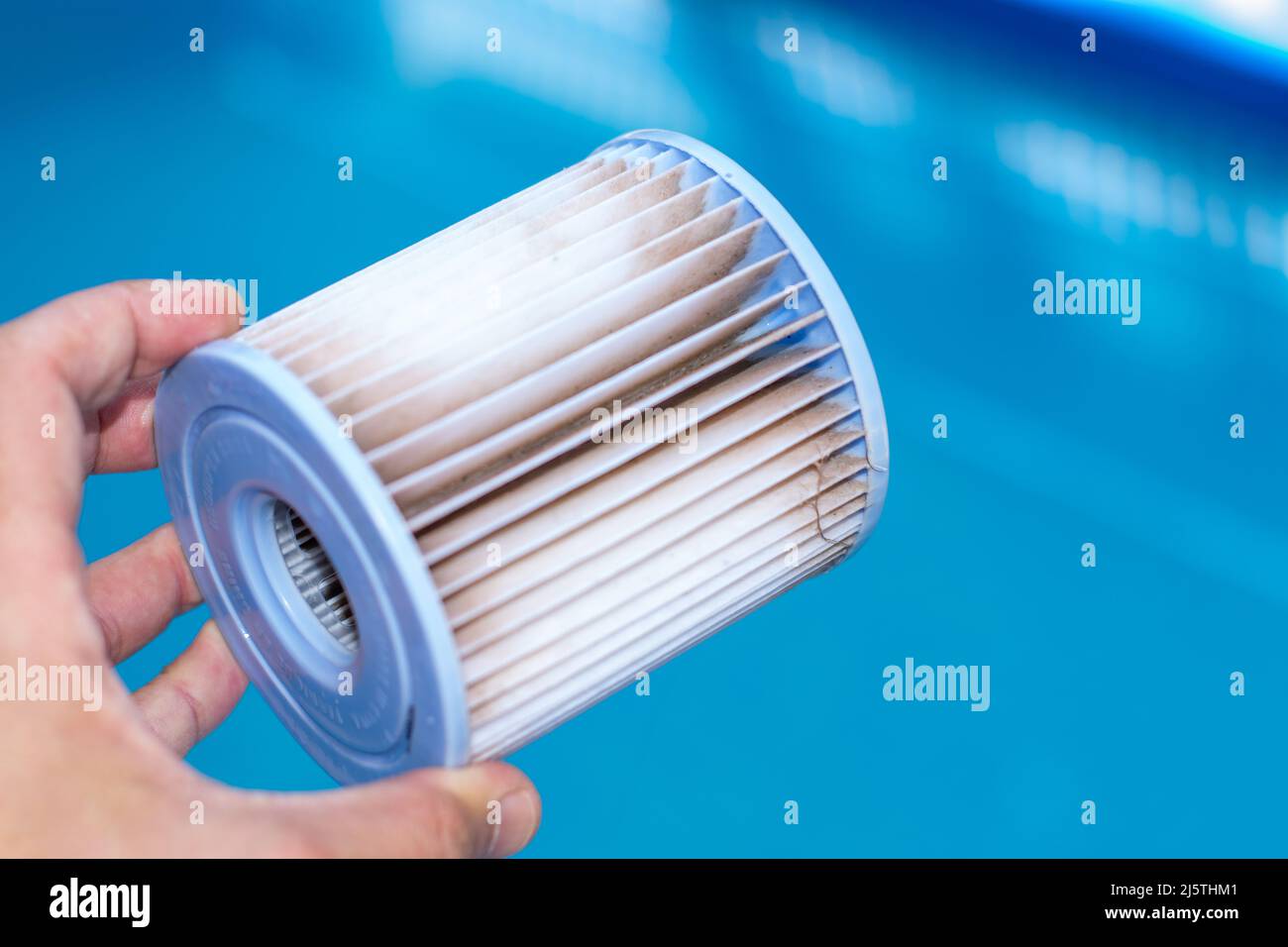 Hand holding a Water filter from pool water pump. Water inspection for