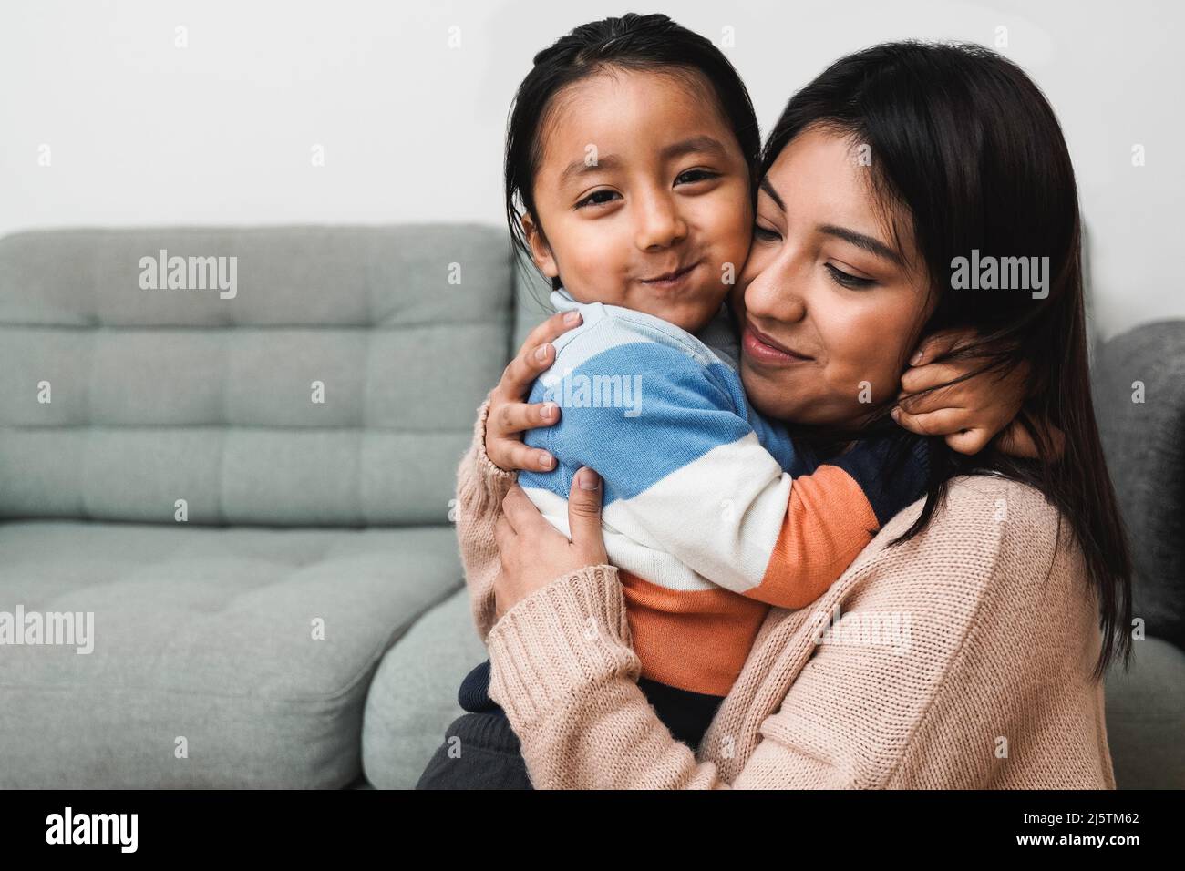 Happy Latin American mother and son hugging each other at home - Family love concept - Focus on child face Stock Photo