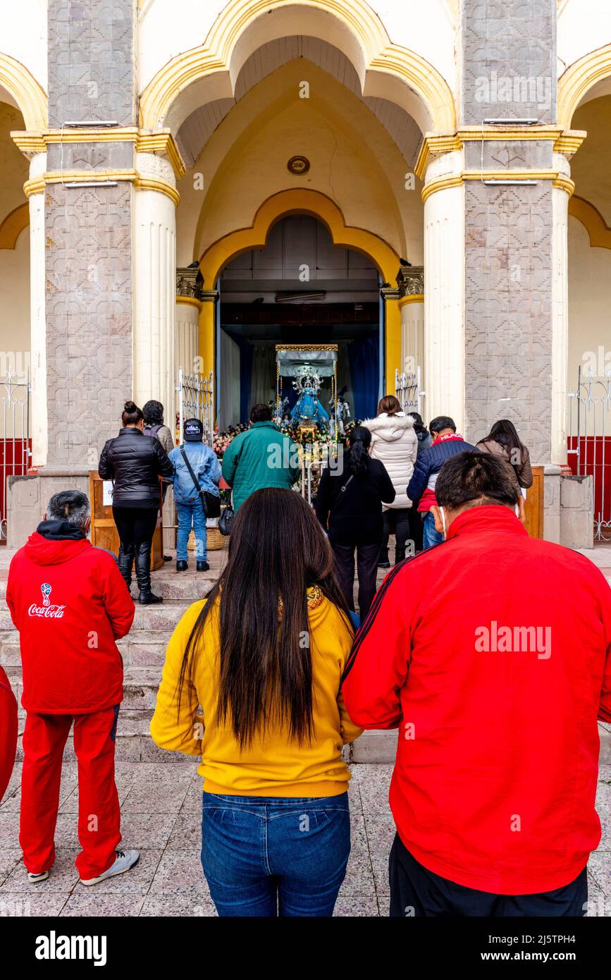 Peruvian Christians Praying Outside The Iglesia de San Juan Bautista, Puno, Puno Province, Peru. Stock Photo