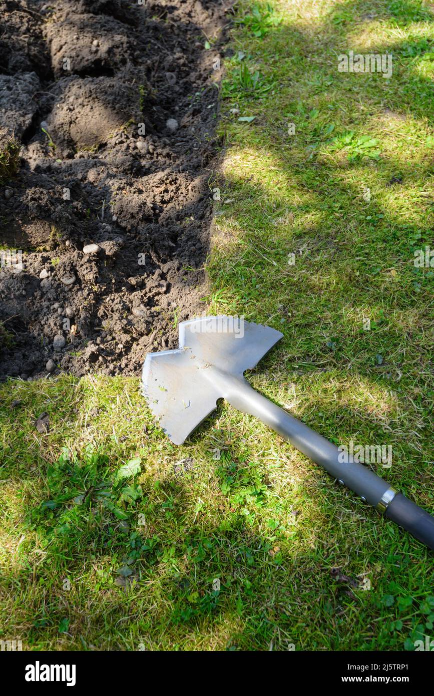 Manual sodturf removal in garden with a steel bordure cutter Stock