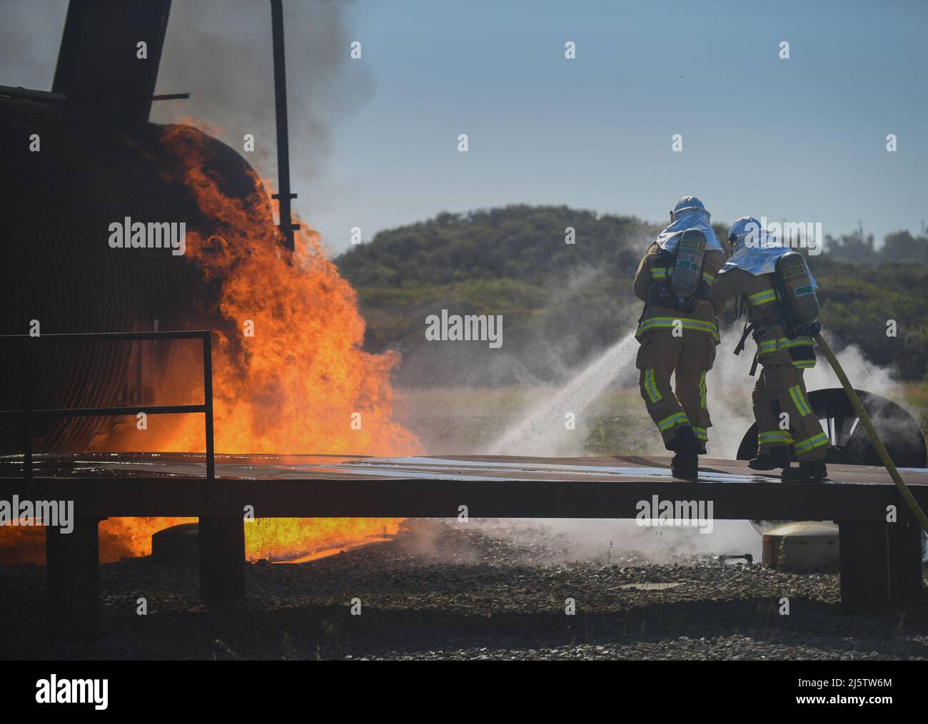 A team of firefighters put out a fire around a training aircraft prior to entering during the joint firefighter integrated readiness ensemble training exercise on Vandenberg Space Force Base, Calif., April 7, 2022.Firefighters around the Department of Defense don the JFIRE while responding to chemical, biological, radiological, or nuclear emergencies. (U.S. Space Force photo by Airman 1st Class Ryan Quijas) Stock Photo