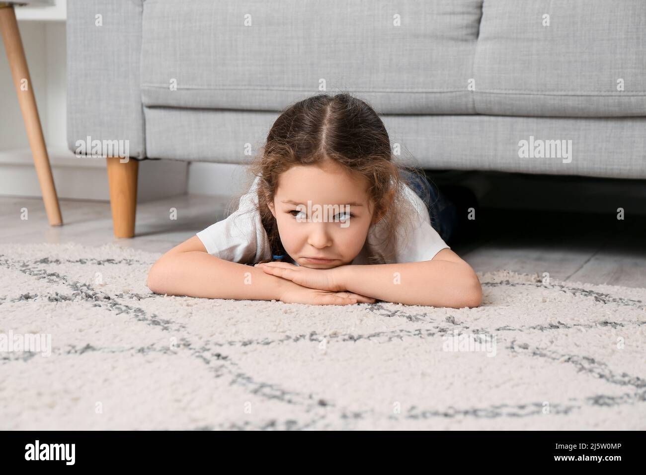 Little girl lying on carpet at home Stock Photo - Alamy