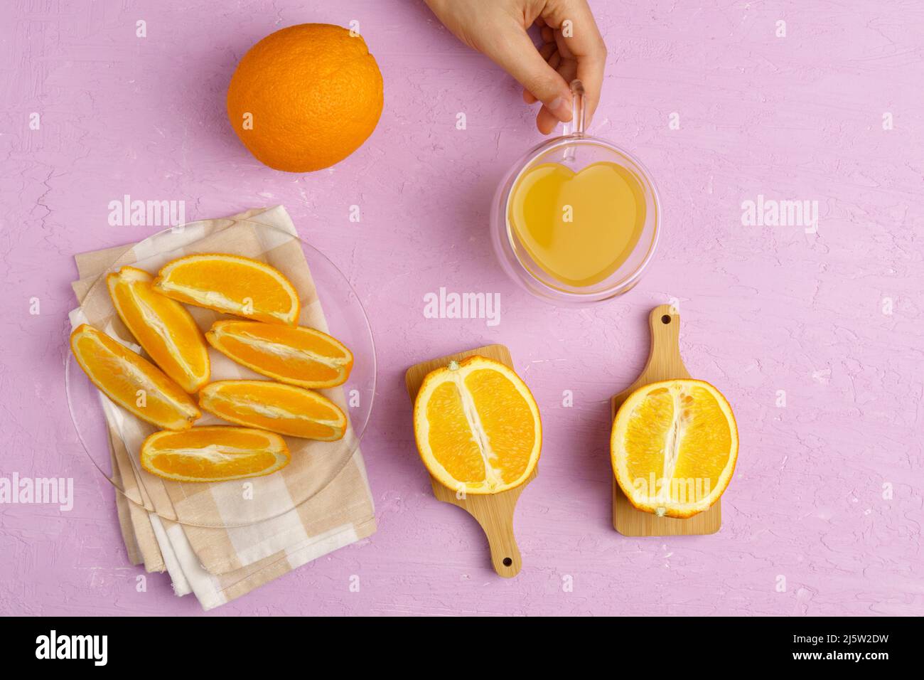 Orange juice orange on a pink background. Preparation of orange juice for health. Flat lay Stock Photo