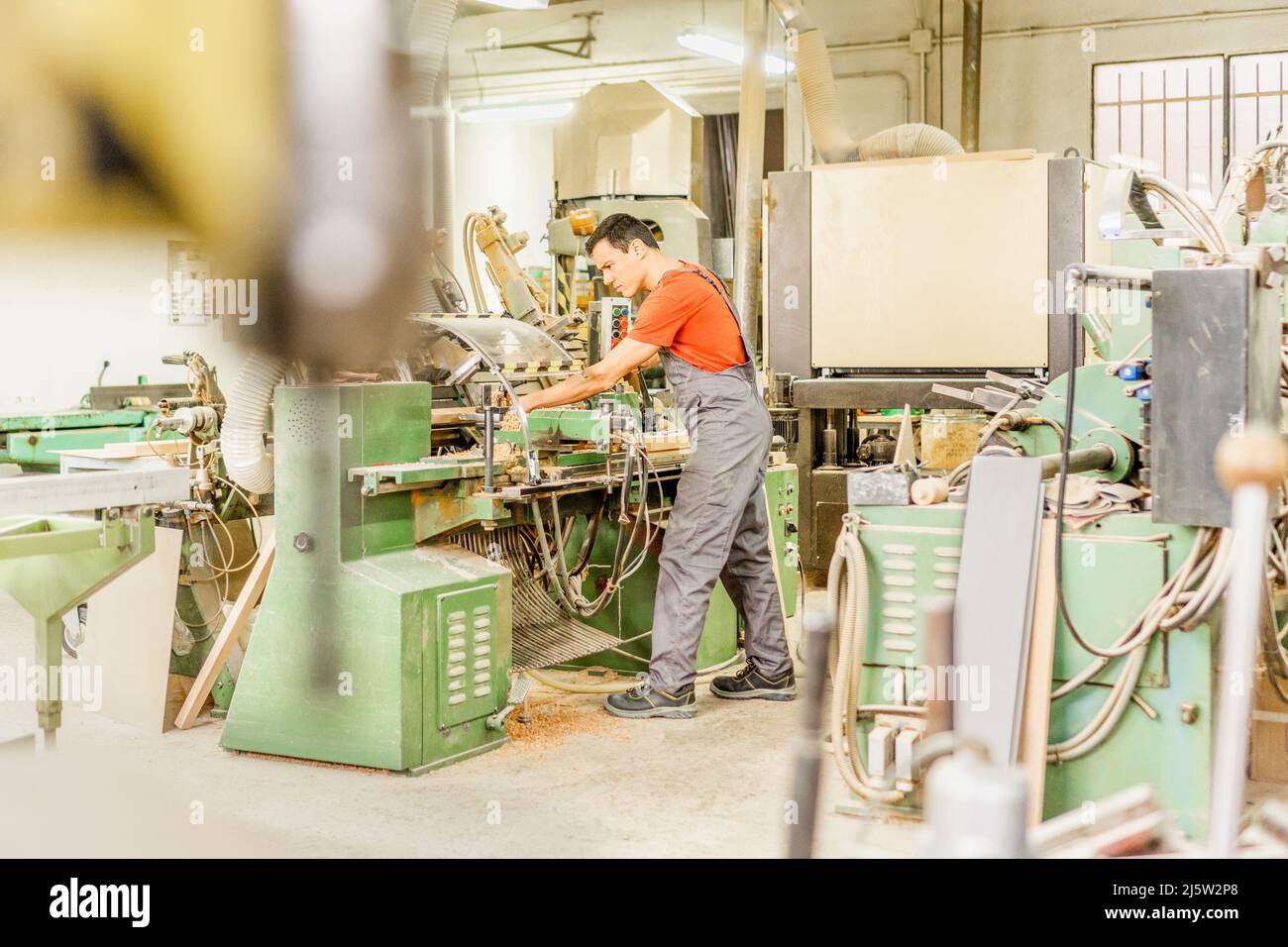 Concentrated carpenter working on equipment in workshop Stock Photo